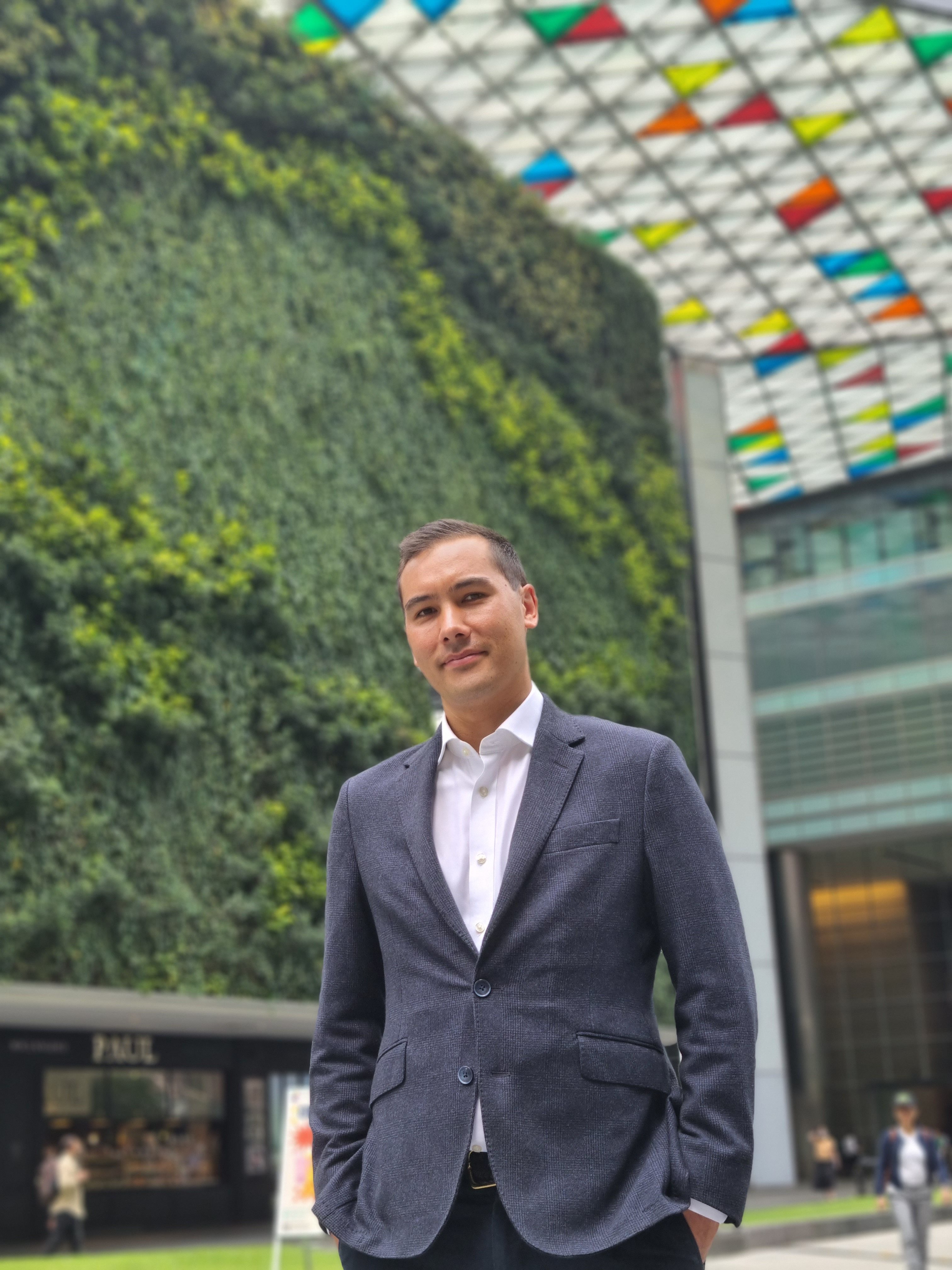 Chris Forbes of CMC Invest Singapore in a dark blue suit, posing for a landscape photograph for a CMC Invest Feature on Jetgala Magazine.